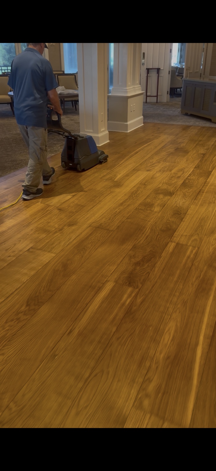 Technician operating a hardwood floor cleaning machine