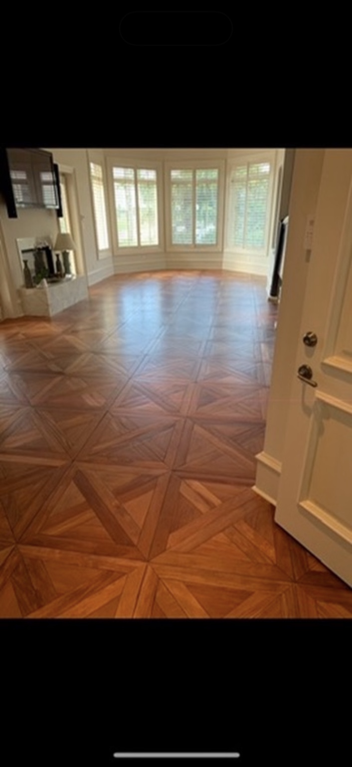 Decorative parquet wood floor in a room with bay windows
