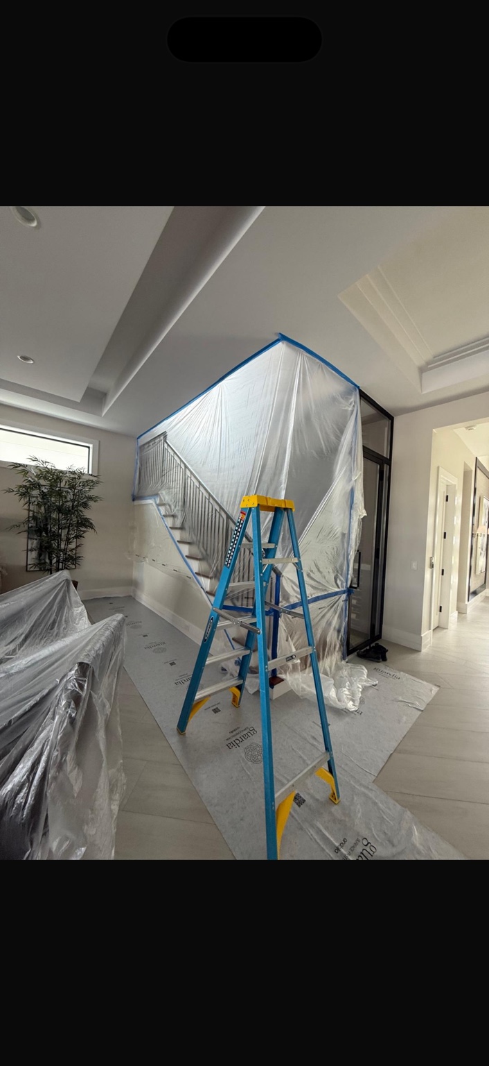 Staircase and surrounding furniture protected with sheeting during refinishing preparation