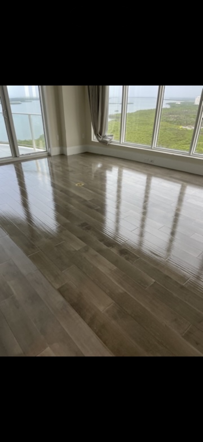 Reflective protective finish on wood flooring beside panoramic windows